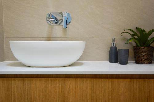 a white bowl sitting on a counter next to a sink at Cottesloe Beachfront Ocean View Apartment in Perth