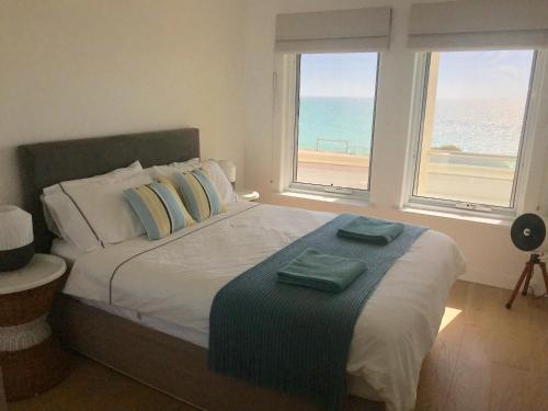 a bedroom with a bed with a view of the ocean at Cottesloe Beachfront Ocean View Apartment in Perth