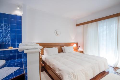 um quarto com uma cama grande e uma banheira em Unique house by the sea em Paralía Proastíou