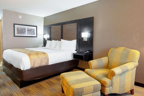 a hotel room with a bed and a chair at Quality Inn Villa Rica in Villa Rica