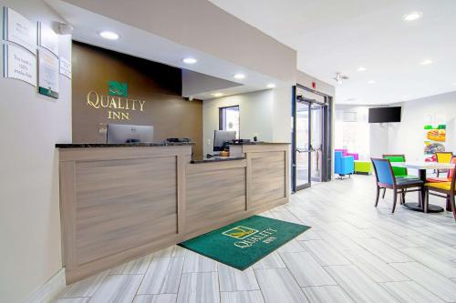 a restaurant with a counter and a table with chairs at Quality Inn Villa Rica in Villa Rica