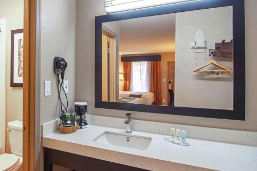baño con lavabo y espejo grande en Quality Inn, en Villa Rica