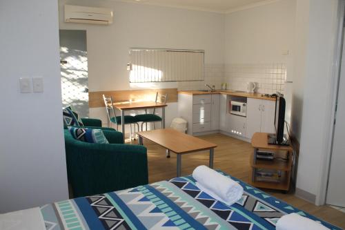 Habitación con cama y cocina con mesa en Mandurah Ocean Marina Chalets en Mandurah