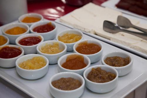a tray filled with different types of food in small bowls at Apucarana Palace Hotel in Apucarana