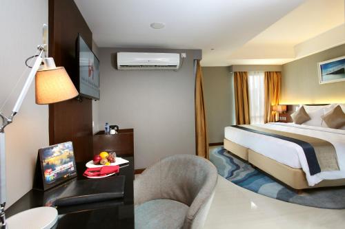 a hotel room with a bed and a desk with a tv at Swiss-Belresidences Rasuna Epicentrum in Jakarta