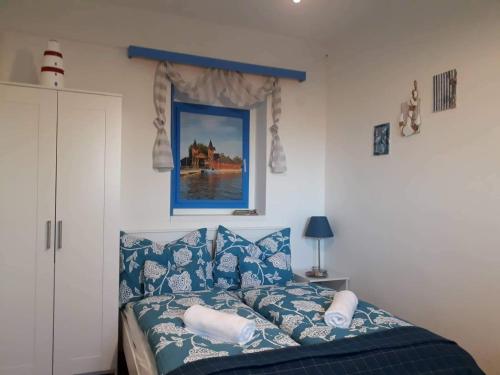 Schlafzimmer mit einem Bett mit blauen und weißen Kissen in der Unterkunft Clara Apartman in Keszthely