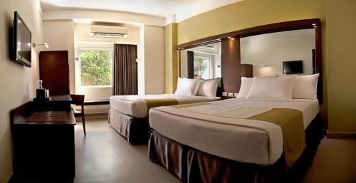 Habitación de hotel con 2 camas y ventana en Microtel by Wyndham Acropolis, en Manila