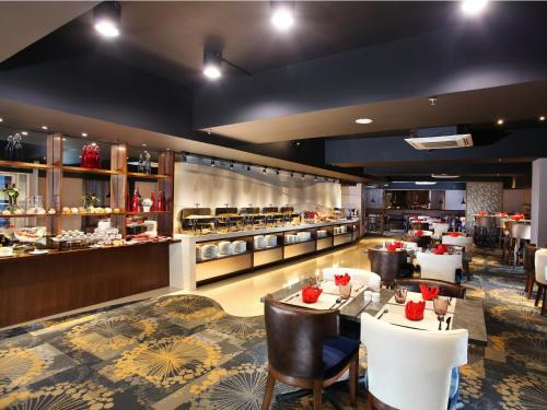 a dining room with tables and chairs and a restaurant at Swiss-Belresidences Rasuna Epicentrum in Jakarta