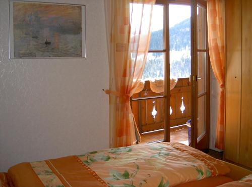 a bedroom with a bed in front of a window at Ferienwohnung Moll in Balderschwang