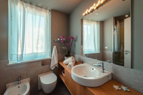 a bathroom with a sink and a toilet and a mirror at The charming house in Taormina