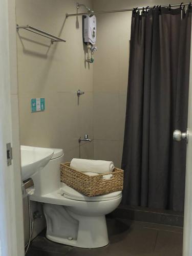 a bathroom with a toilet with a sink and a shower at Treetop Suites in Coron