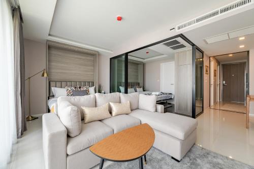 a living room with a white couch and a bed at Sukhumvit Asok Modern Suite in Bangkok