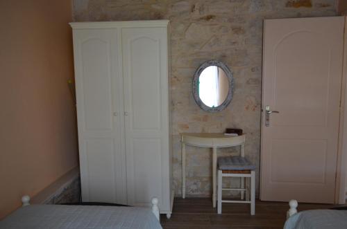 a bedroom with a bed and a mirror and a table at La Villa "Casa di Lydia" in Gavalochori
