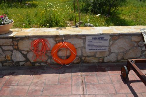 a stone wall with an orange life preserver on it at La Villa "Casa di Lydia" in Gavalochori