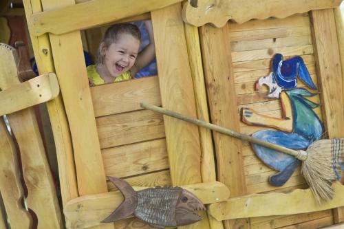 a young child is looking out of a wooden play house at Danubius Hotel Marina in Balatonfüred