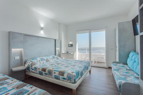 a bedroom with two beds and a view of the ocean at Hotel Asiago Beach in Lido di Savio