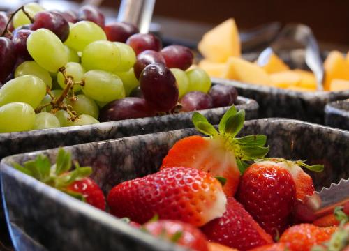 two baskets of strawberries and grapes and other fruit at Meiser Altstadt Hotel in Dinkelsbühl