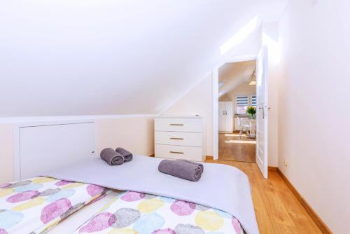 a white bedroom with a large bed with two pillows at Apartament Olivia Chlapowo/Wladyslawowo in Władysławowo