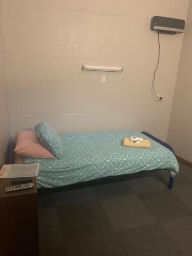 uma pequena cama num quarto com telefone em The Railway Hotel em Queenstown