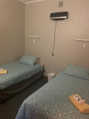 um quarto com duas camas e um ar condicionado na parede em The Railway Hotel em Queenstown