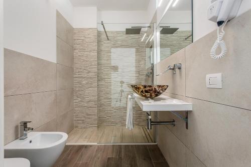 un baño con lavabo y un bol en la encimera en Hotel Asiago Beach, en Lido di Savio