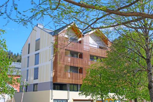 an apartment building with a red balcony at Ferienwohnung Narzisse - City Appartement im Kurpark Bad Aussee in Bad Aussee