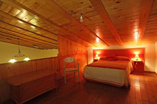 1 dormitorio con cama y techo de madera en Casa Rural Casa de las Aves, en Orellana la Vieja
