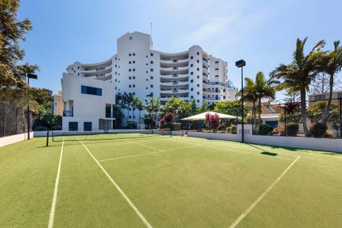 a tennis court with a tennis racquet on a sunny day at Ramada Resort by Wyndham Golden Beach in Caloundra