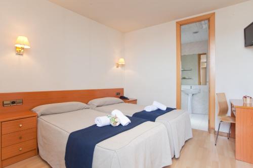 a bedroom with two beds with towels on them at Hotel Everest in Barcelona