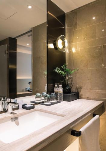 a bathroom with a sink and a mirror at Harbin Week Inn Hotel in Harbin