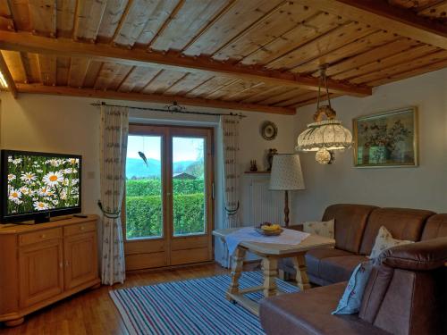 ein Wohnzimmer mit einem Sofa und einem TV in der Unterkunft Ferienwohnung Ulrich Wurmser in Rottach-Egern