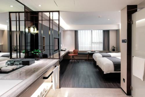 a hotel room with two beds and a bathroom at Harbin Week Inn Hotel in Harbin