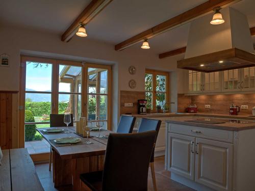 a kitchen with a table with chairs and a large window at Ferienwohnung Ulrich Wurmser in Rottach-Egern