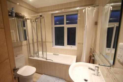 a bathroom with a tub and a sink and a toilet at Oak Tree in London