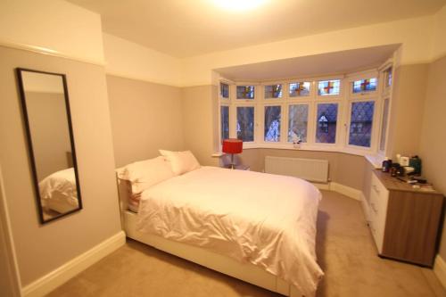 a bedroom with a white bed and a mirror at Oak Tree in London