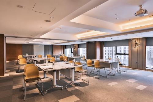 a conference room with tables and chairs and windows at Harbin Week Inn Hotel in Harbin