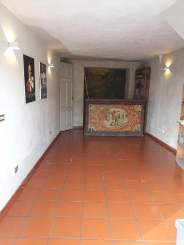 a room with an orange tile floor and a painting on the wall at Sciala' in Taormina