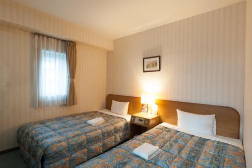 Giường trong phòng chung tại Benikea Calton Hotel Fukuoka Tenjin