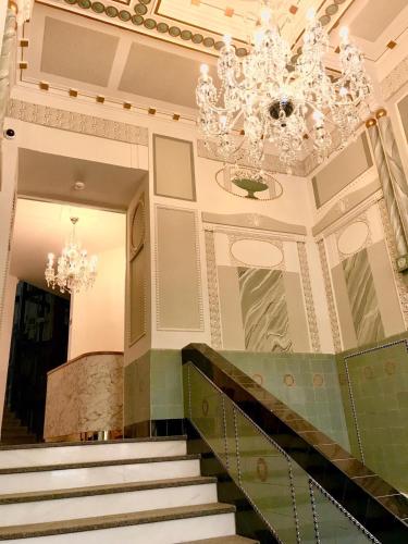 a staircase in a building with a chandelier at Gold Art Apartments in Prague