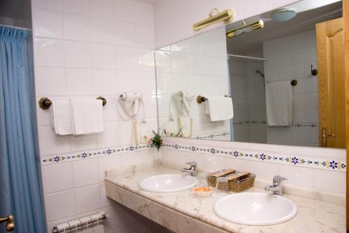 a bathroom with two sinks and a mirror at Astur Regal in Cadavedo