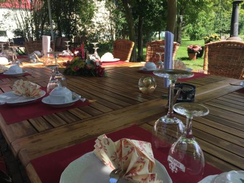 Una mesa de madera con platos y copas de vino encima. en Lindenhof Peritz, en Peritz
