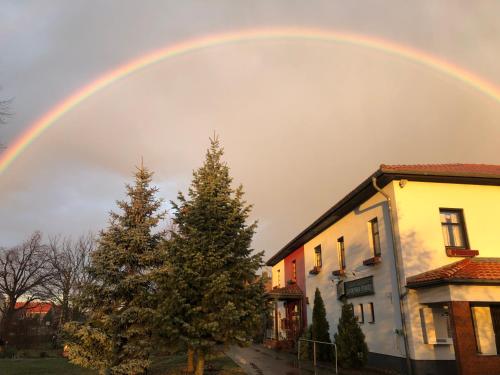 Ein Regenbogen am Himmel über einem Haus und einem Baum in der Unterkunft Lindenhof Peritz in Peritz