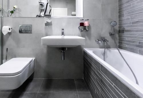 a bathroom with a sink and a bath tub at More Than Accommodation in Bratislava