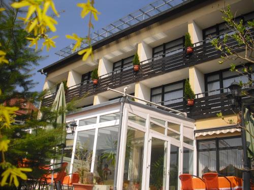 an exterior view of a building with orange chairs at Panorama Hotel Pension Frohnau in Bad Sachsa