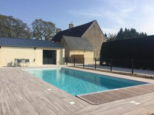 une piscine devant une maison dans l'établissement Ferme de Riou, à Sainte-Mère-Église