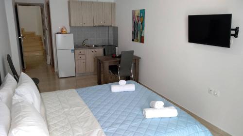 um quarto com uma cama e uma cozinha com um frigorífico em Violetta Studios em Paralion Astros