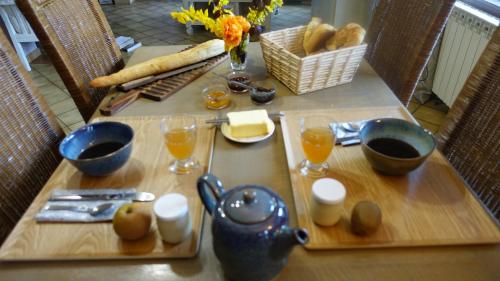 a table with bread and glasses of orange juice at Le jardin des secrets in La Voivre