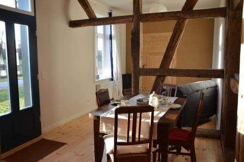 a dining room with a wooden table and chairs at Ferienwohnung Heidjerleev in Eldingen