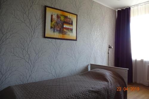 1 dormitorio con 1 cama y una foto en la pared en Prenzel Apartments - Mai, en Pärnu