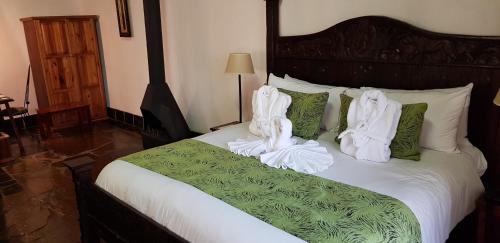 a bedroom with a bed with white towels on it at Misty Hills Country Hotel, Conference Centre & Spa in Muldersdrift